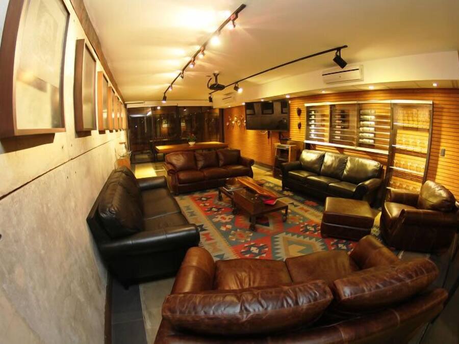 A spacious living room with leather sofas, a coffee table, and a patterned rug.