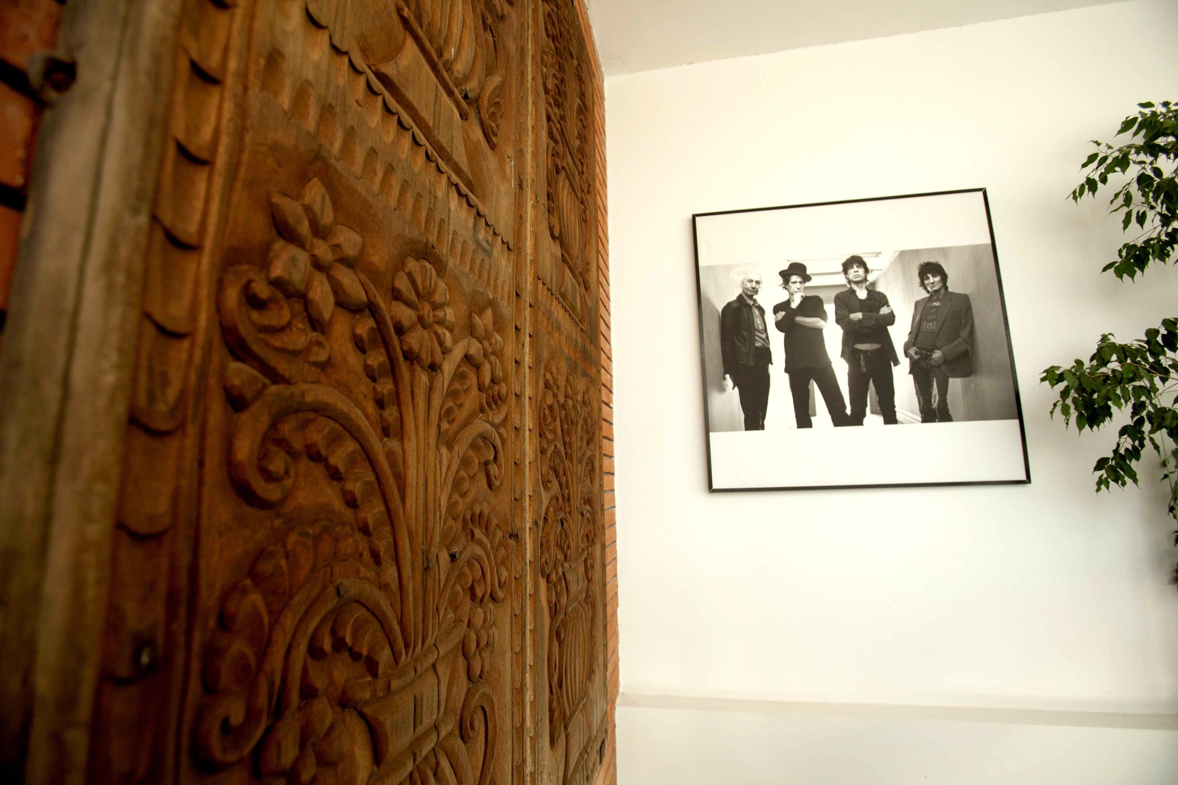 A carved wooden panel with a framed black and white photograph on the wall.