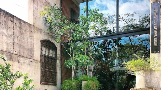 A building entrance with steps leading up to a glass door, a plaque reading "Coco Kl Primer B", and a sign for "Inmobili Calupo". - Alfonsina Hotel Boutique by Inboccaluppo (Santa Cruz)