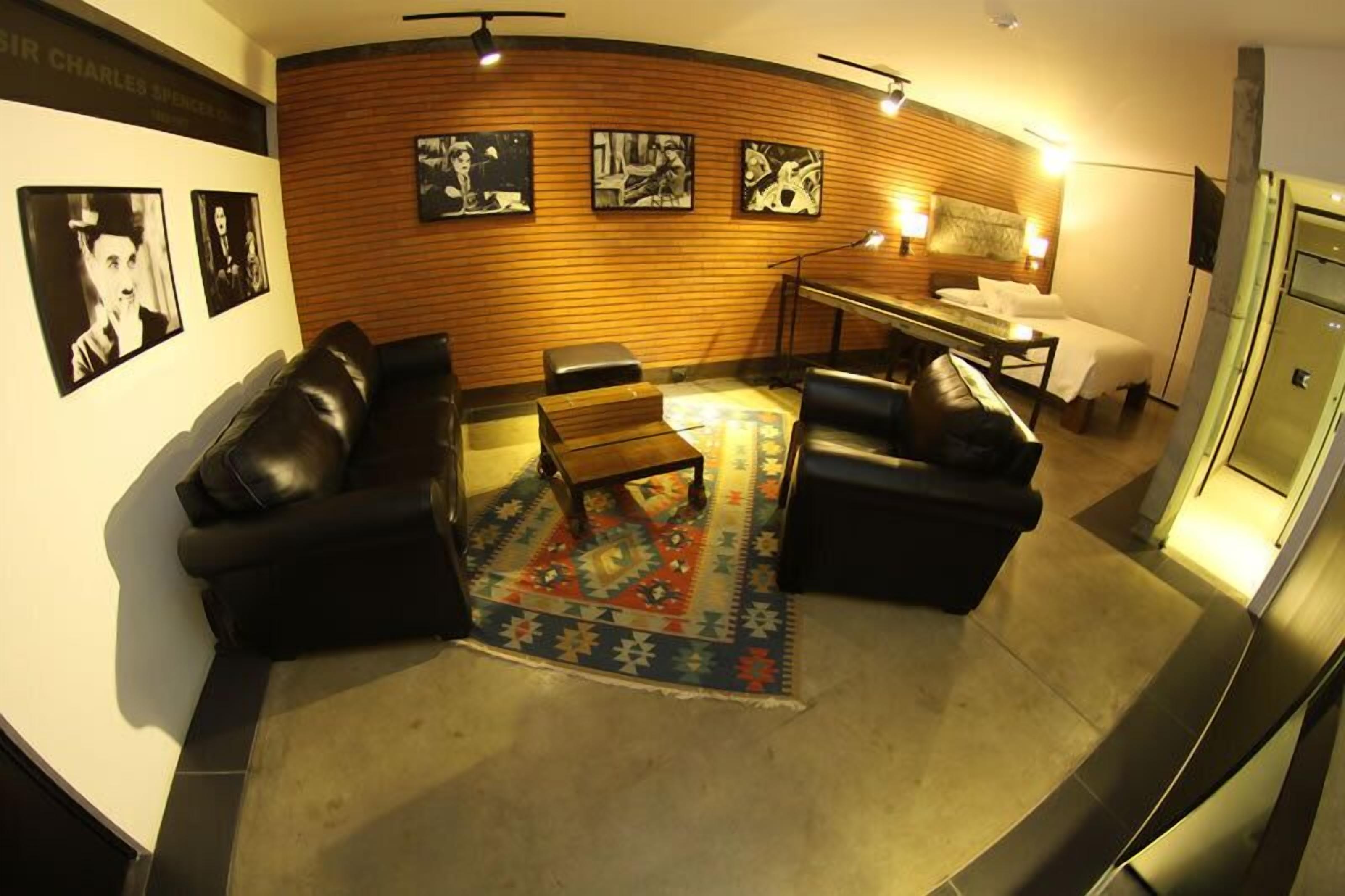 A modern living room with a wooden accent wall, a patterned rug, and a seating area with a coffee table.