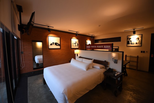 A hotel room with a large bed, a bedside table with a lamp, a mirror, and framed pictures on the wall. - Alfonsina Hotel Boutique by Inboccaluppo (Santa Cruz)