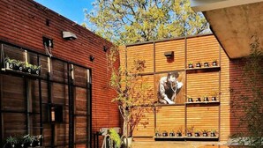 An outdoor dining area with a brick wall, wooden shelves with plants, and a table set with plates of food and drinks. - Alfonsina Hotel Boutique by Inboccaluppo (Santa Cruz)