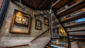 A staircase with a metal railing, wooden steps, and a concrete wall with framed pictures. - Alfonsina Hotel Boutique by Inboccaluppo (Santa Cruz)