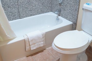 A bathroom with a bathtub and toilet. - Stagecoach Inn (Molalla)