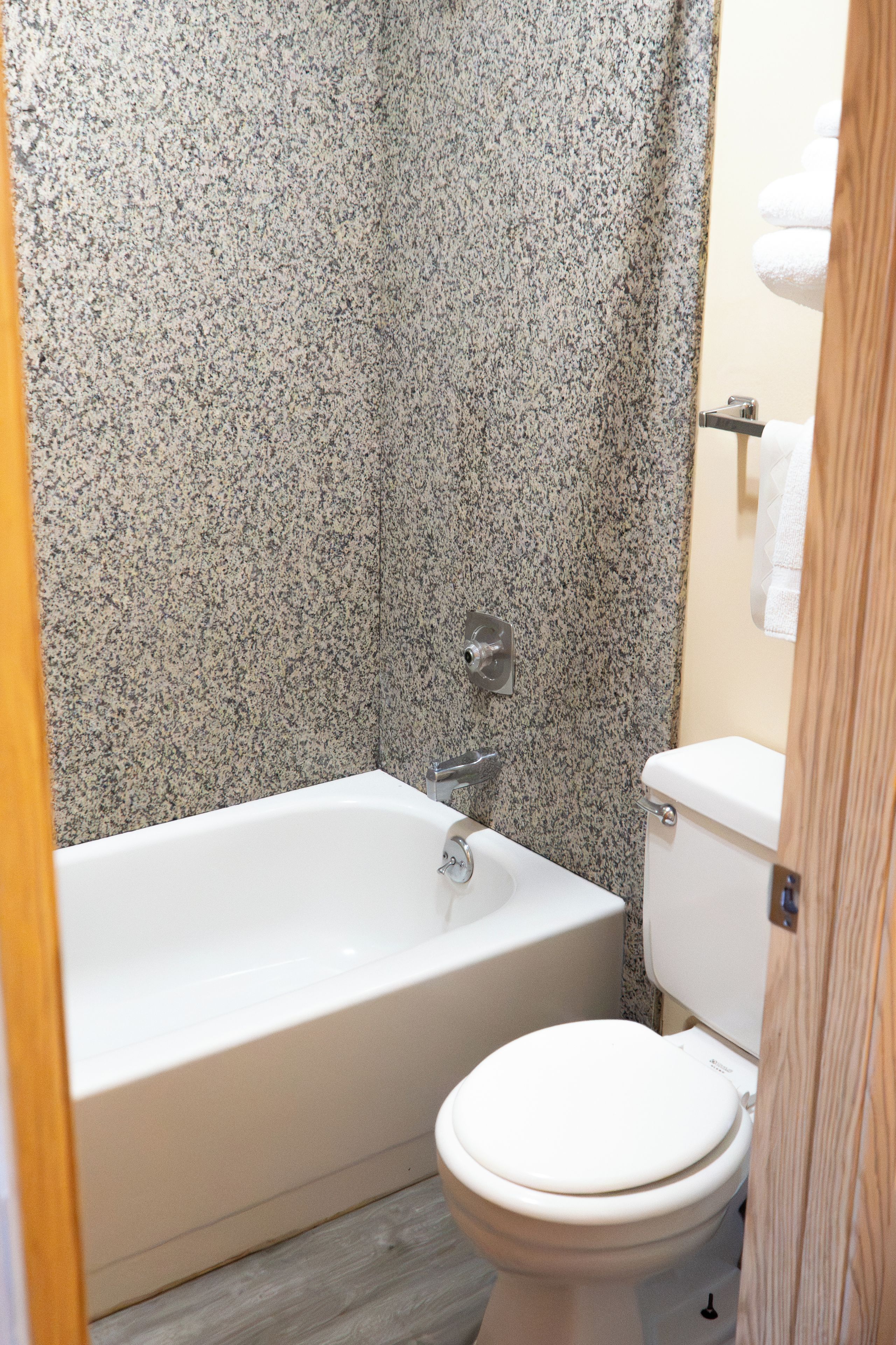 Ein Badezimmer mit Badewanne, Toilette und Duschbereich.