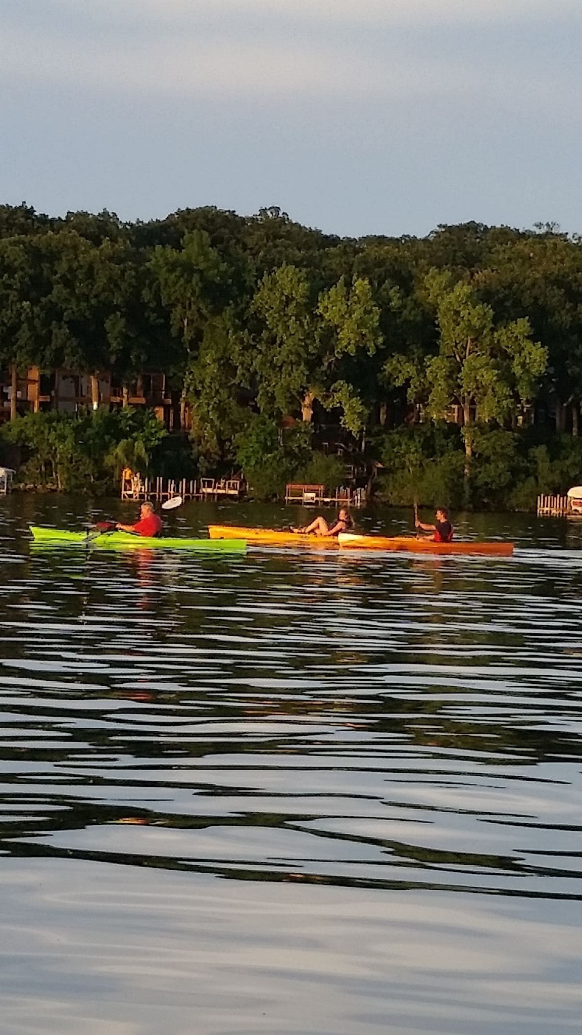 A calm lake with several kayaks.