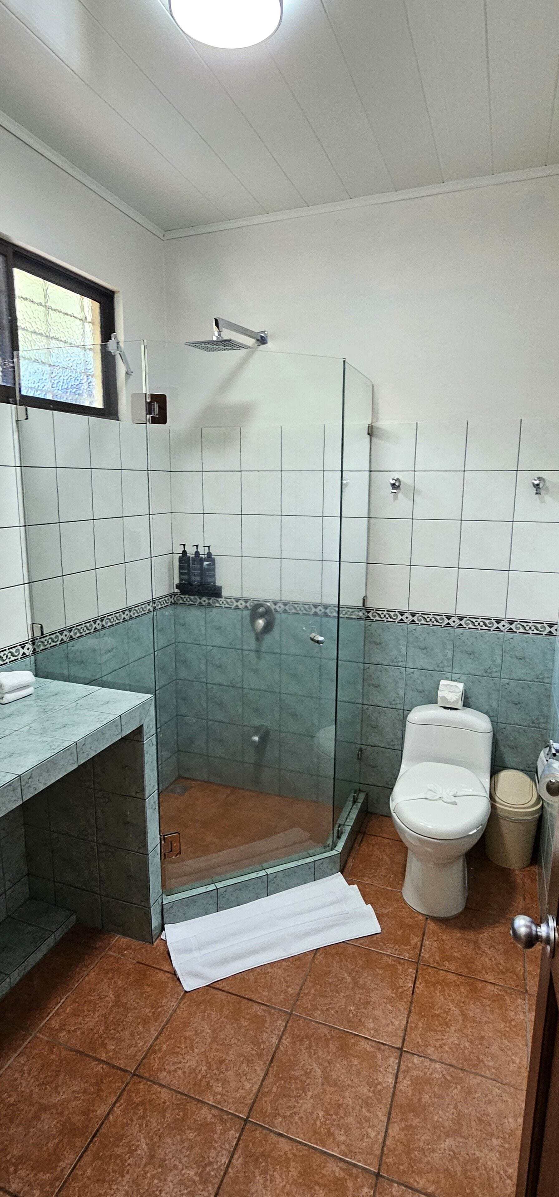 A bathroom with a shower, toilet, and sink.