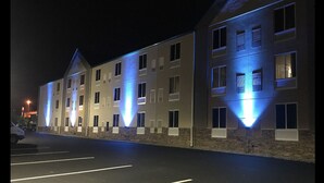 A multi-story hotel with a modern design, featuring a parking lot in front. - Plymouth Bay Inn and Suites (Kingston)