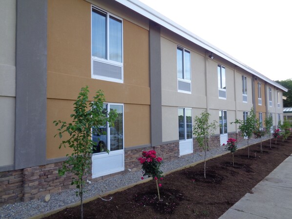 A modern building with multiple windows and a brick foundation.
