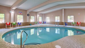 An indoor swimming pool with a tiled floor and a pool ladder. There are several chairs with towels around the pool. - Plymouth Bay Inn and Suites (Kingston)