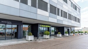 Een modern gebouw met een B&B-hotel en een winkel genaamd MAGENTA EKO.