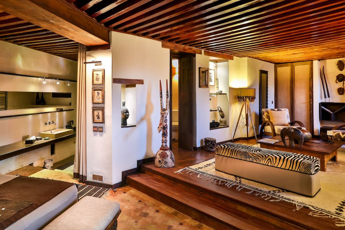 Ein modernes Interieur mit Küche, einem Wohnbereich mit Sofa und Couchtisch sowie einer Treppe, die in eine andere Ebene führt.