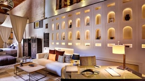 Une chambre d’hôtel moderne équipée d’un canapé, d’une table basse et d’un bureau avec une lampe.