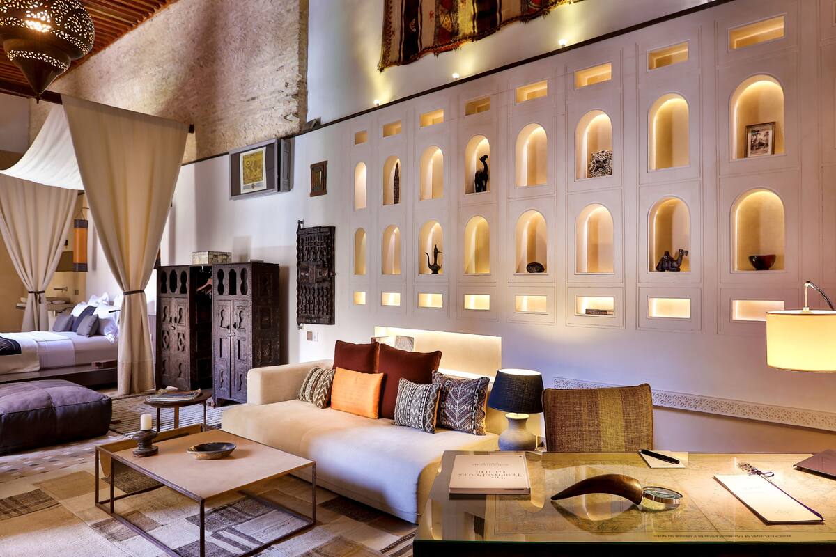 Ein modernes Hotelzimmer mit Sofa, Couchtisch und Schreibtisch mit Lampe.