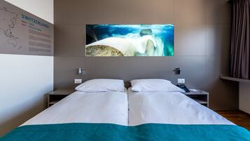 Une chambre d’hôtel avec un lit, une carte accrochée au mur et une grande photo d’un iceberg.