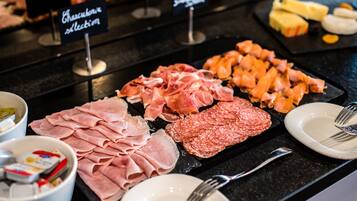Un assortiment de viandes est présenté sur un comptoir, chaque variété étant clairement indiquée par une étiquette.