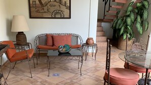 A living room with a sofa, chairs, a coffee table, and a painting on the wall. - Hotel La Posada del Angel (San Salvador)