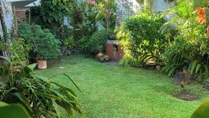 A lush garden with a variety of plants and a well-maintained lawn. - Hotel La Posada del Angel (San Salvador)
