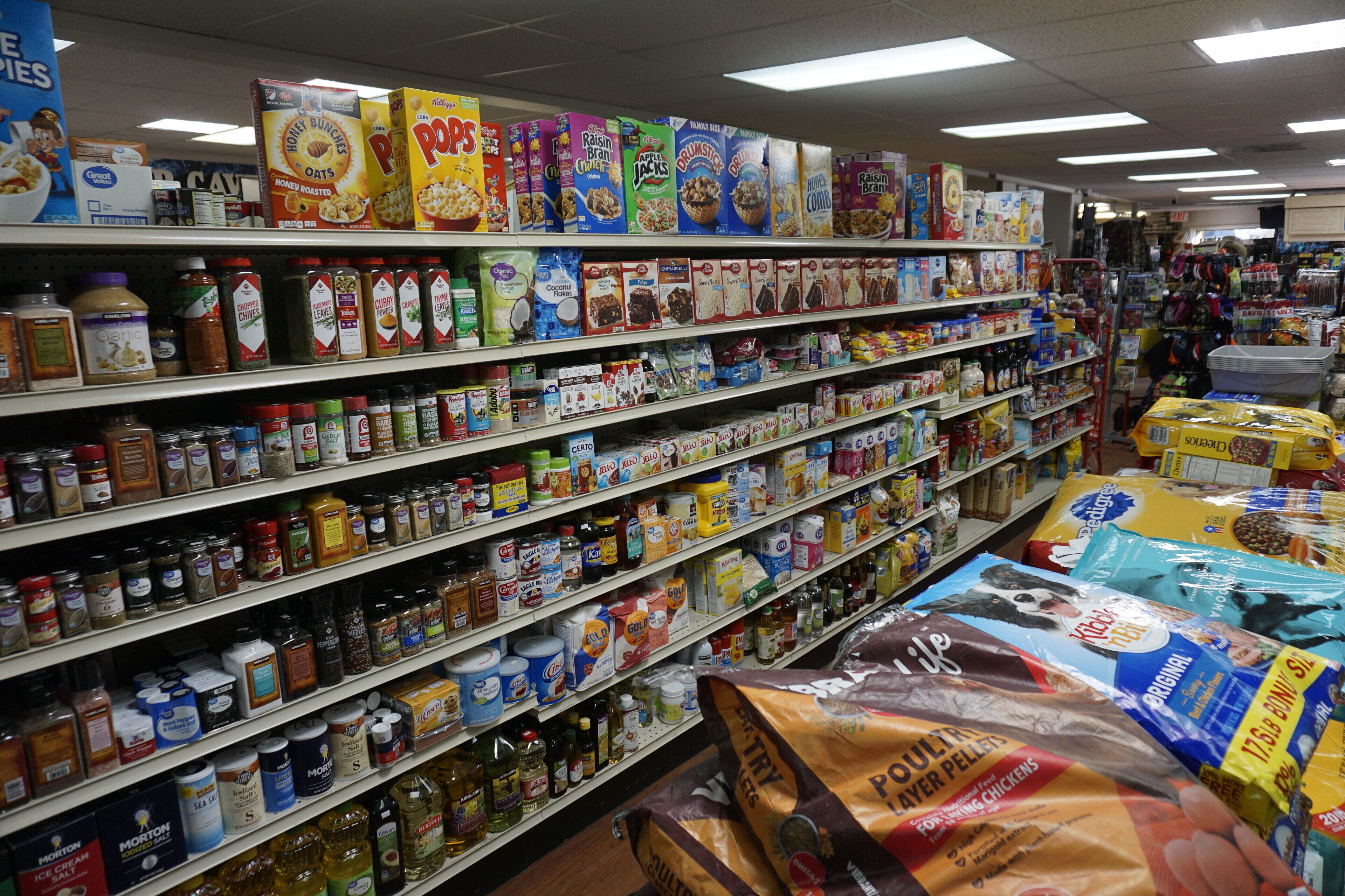 A grocery store aisle with various food products and household items.