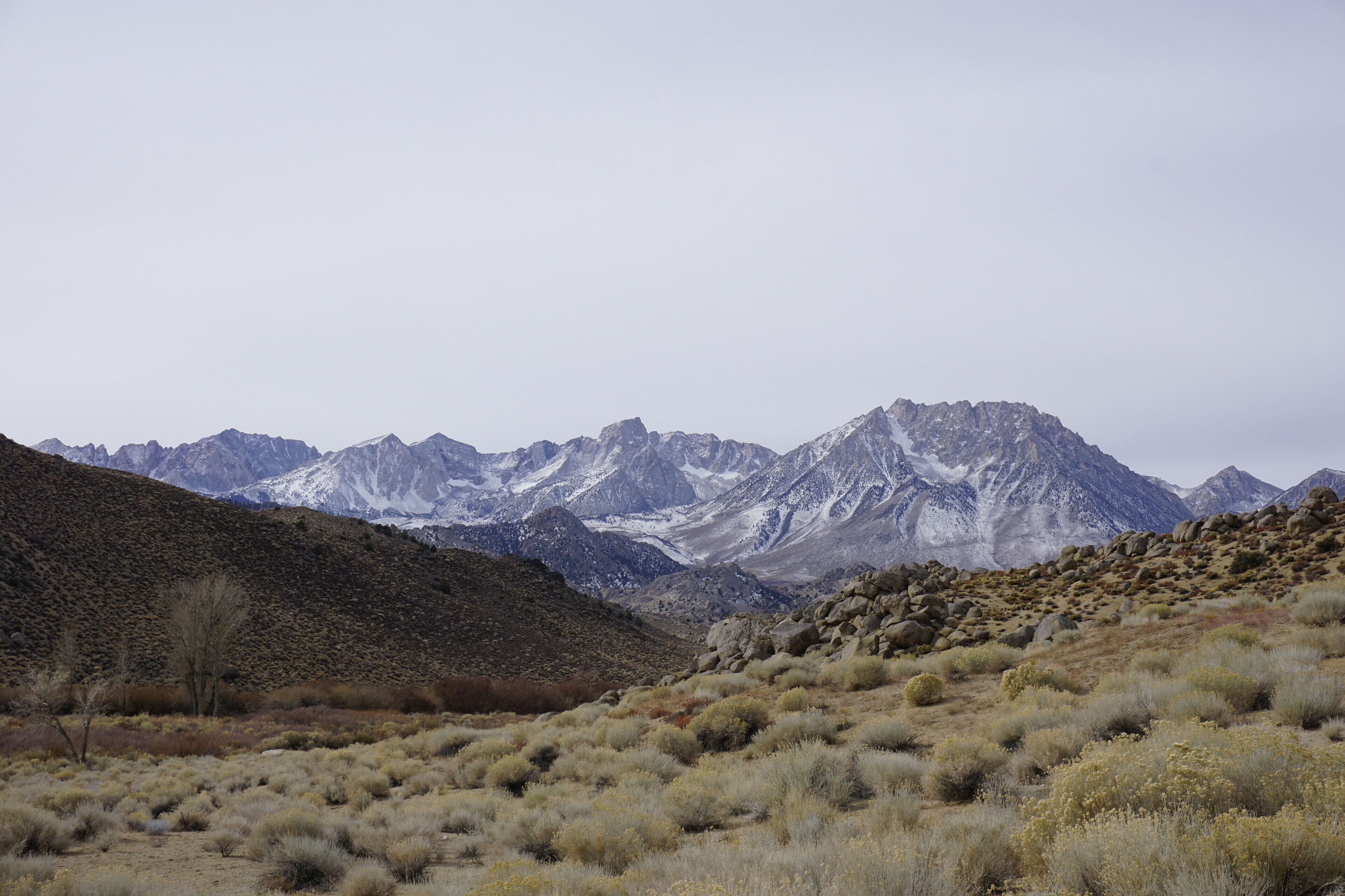 A mountainous landscape with sparse vegetation and rocky terrain.