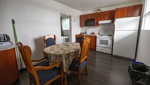 Una cocina compacta con gabinetes de madera, un microondas, un horno y un refrigerador.