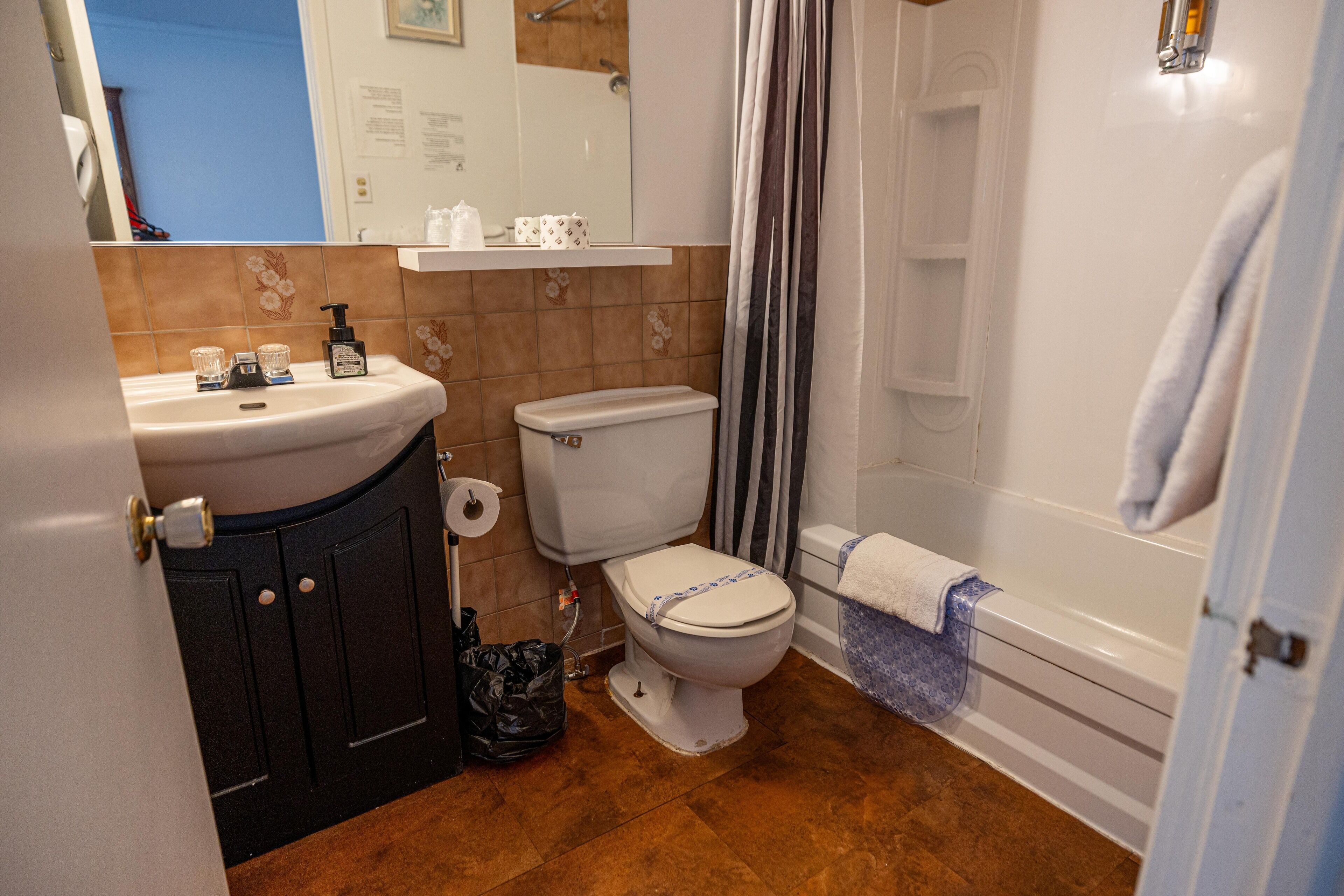 Une salle de bain comprenant des toilettes, un lavabo et un espace douche.