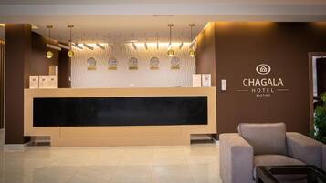 Una recepción con diseño moderno, un reloj y un letrero del Hotel Chagala.