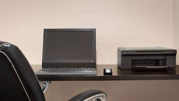A desk with a laptop, a printer, and a mouse.