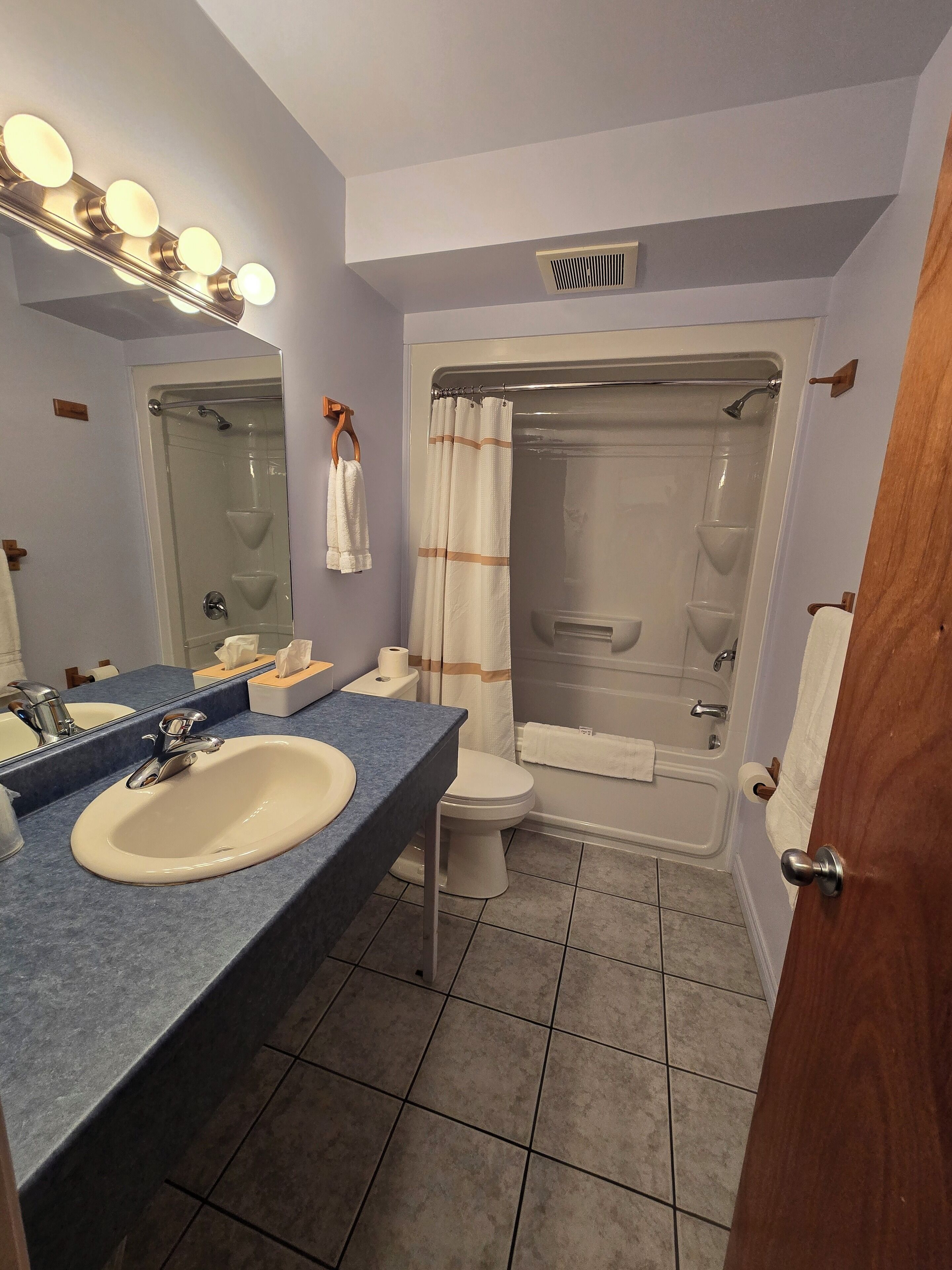 A bathroom with a sink, toilet, and shower.