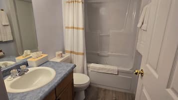 A bathroom with a sink, toilet, and bathtub.