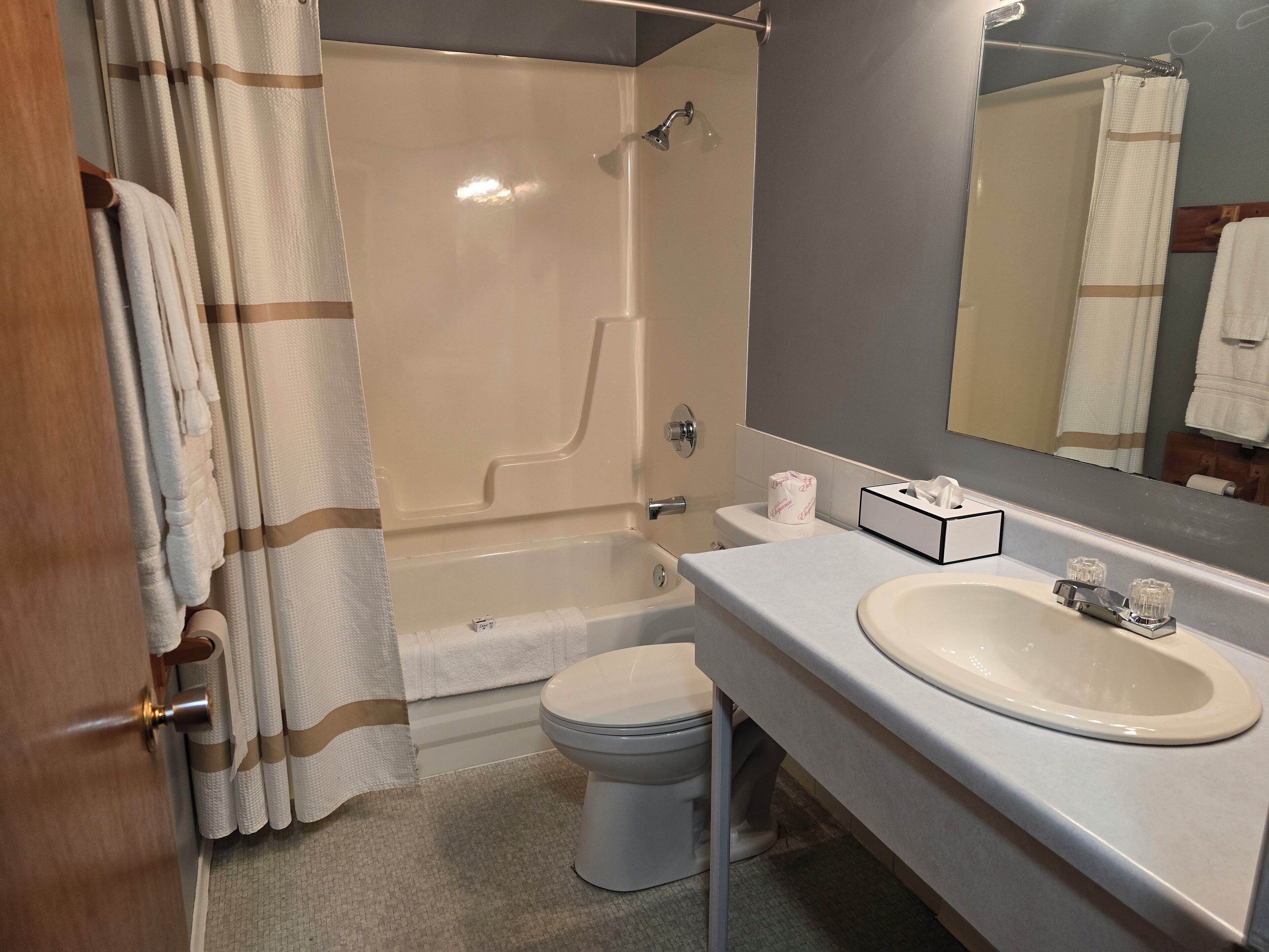 Un bagno con vasca, WC e lavandino.