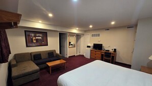 Une chambre d’hôtel équipée d’un lit, d’un canapé, d’un bureau avec un ordinateur et d’une télévision.