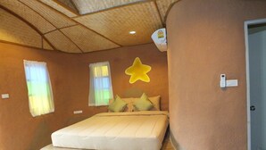 Un dormitorio con una cama, una decoración de estrellas y un termostato en la pared.