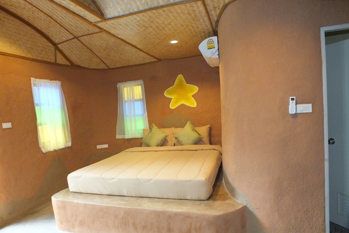 Une chambre à coucher avec un lit, une décoration en forme d’étoile et un thermostat fixé au mur.