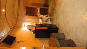 Un cuarto de spa con una mesa de masaje, un ventanal pequeño y un banco de madera.