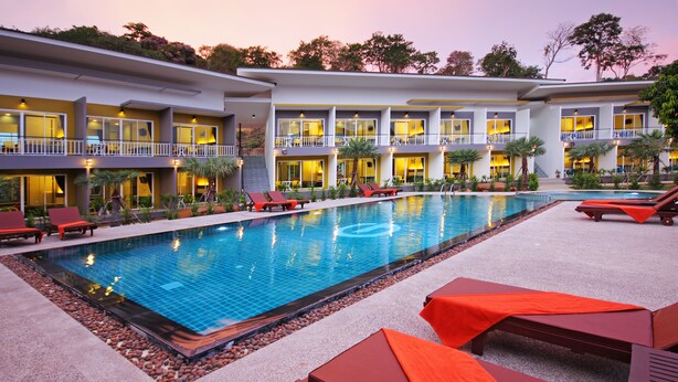 A hotel with a swimming pool, multiple balconies, and sun loungers. - Gypsy Sea View Resort (Ko Phi Phi)