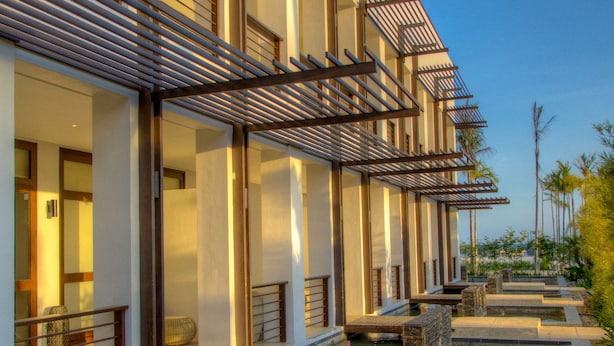Een modern hotel met een zwembad, inclusief een fontein en een houten terras.