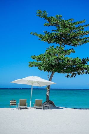 Privatstrand, weißer Sandstrand, Liegestühle, Sonnenschirme