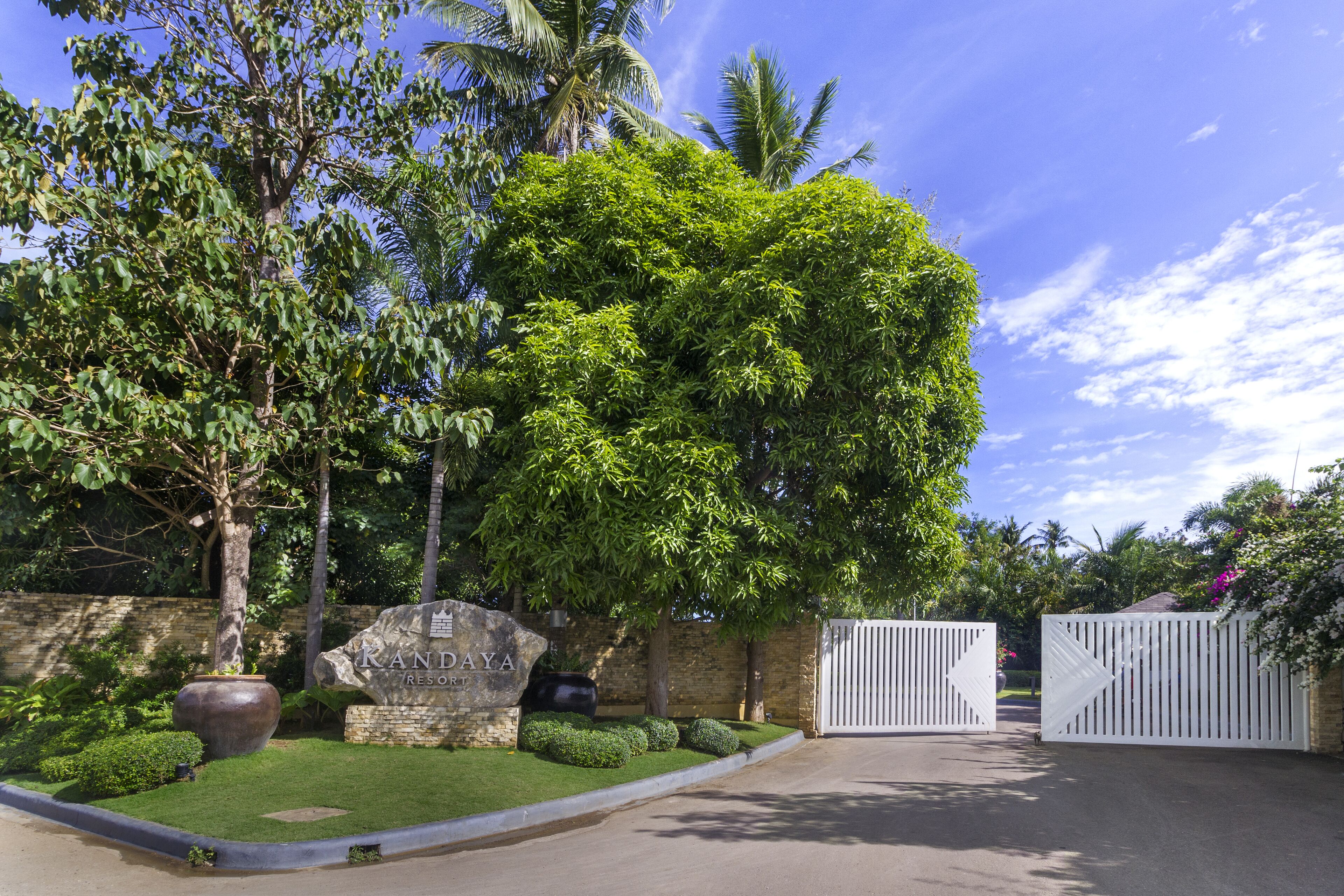 A gated entrance to a property named 'Randaya Resort' with lush greenery and palm trees.
