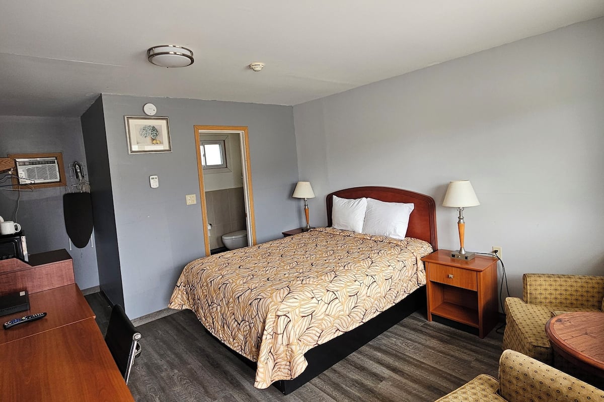 Une chambre d’hôtel comprenant un lit, des tables de chevet, un bureau et une chaise.
