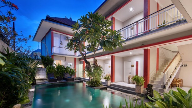 A two-story building with a swimming pool, outdoor seating, and a staircase. - Angkul Angkul Beach In Kuta (Kuta)