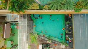 Vista aérea de una piscina rodeada de vegetación y una terraza de madera.