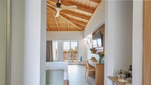 A modern bedroom with a wooden ceiling, a bed, a desk, and a view of the outdoors. - Mystery Skiathos Luxury Residence  (Skiathos)