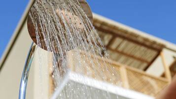 A person using a showerhead with water flowing down.