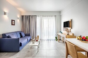 Suite superior, vista a la alberca | Área de sala de estar | Televisión 