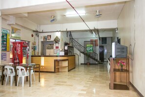 A hotel reception area with a Coca-Cola refrigerator, a reception desk, and a staircase leading to another floor. - GV Hotel Dipolog City (Dipolog)