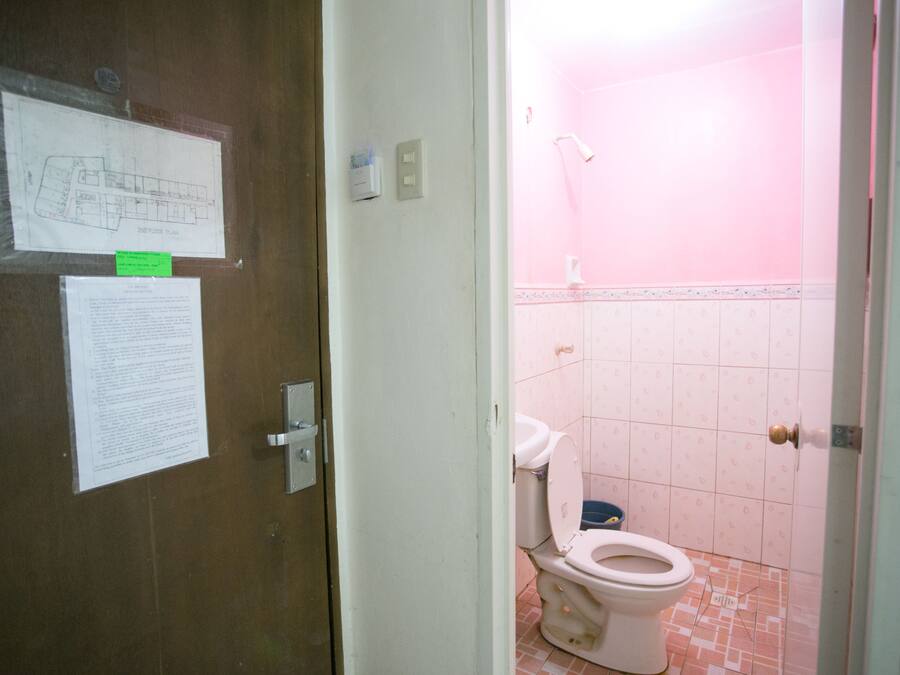 Un baño con inodoro, ducha y piso de baldosas.
