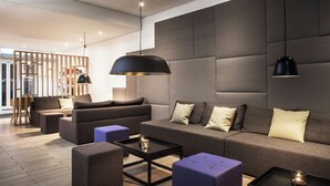 Una sala de estar moderna con un sofá seccional, una mesa de centro e iluminación colgante.