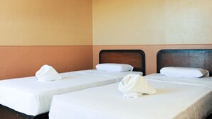 A hotel room with two single beds, each with a white bedspread and a neatly folded towel. - GV Hotel Ipil (Ipil)