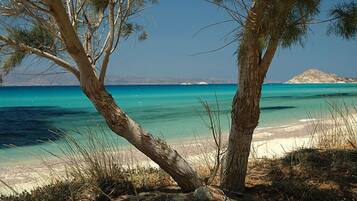 Praia particular, areia branca, espreguiçadeiras, guarda-sóis